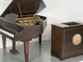 Ein Flügel und ein Holzgehäuse mit Lautsprecher, die zusammen den Beginn des Electronica-Genres markieren.