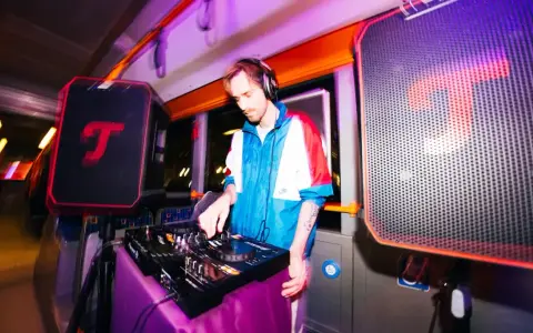 DJ legt auf, während im Hintergrund eine **classical music playlist** läuft. Bunte Lichter und Lautsprecher schaffen eine einzigartige Atmosphäre.