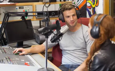 Mann und Frau mit Kopfhörern im Tonstudio, ein Beispiel für spannende Jobs in der Musikindustrie.