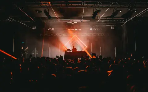 DJ legt auf, die Menge jubelt im Scheinwerferlicht. Ein pulsierendes Erlebnis im techno genre.