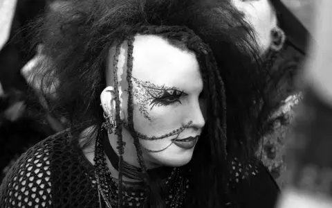 Ein Mitglied einer Gothic Rock Band mit auffälligem Make-up und Frisur.