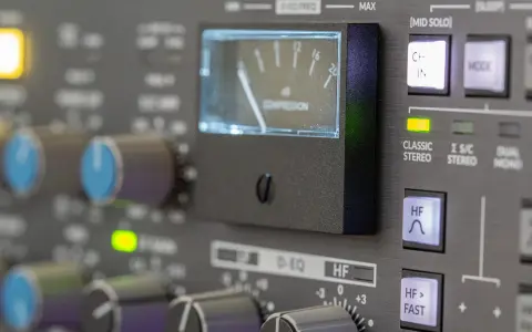 Regler und VU-Meter eines Mischpults, das die analoge Welt der Musikproduktion zeigt.