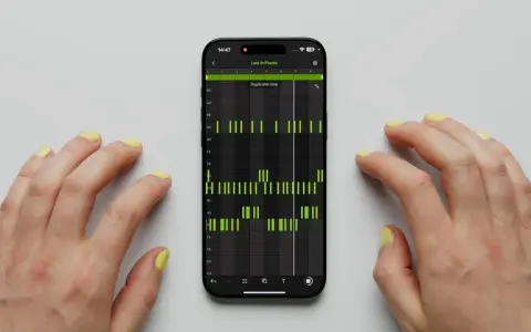 Hände tippen auf einem Smartphone, das die Ableton Note App mit einer Musiksequenz zeigt.