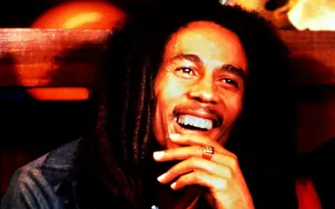 Bob Marley lacht herzlich, ein Symbol für die besten Reggae-Musik-Hits.