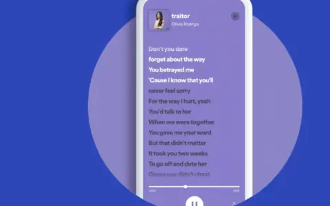 Lyrics von "traitor" von Olivia Rodrigo bei Spotify. Der Songtext wird auf einem Smartphone angezeigt.